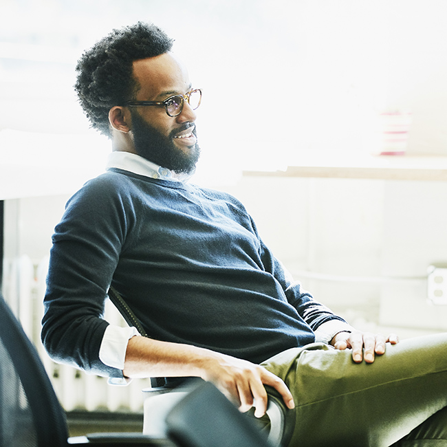 Un homme professionnel assis de manière détendue sur une chaise de bureau