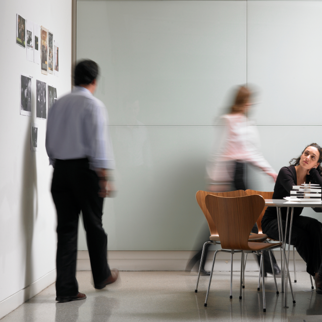 Une femme assise à une table, absorbée par son travail, concentrée et déterminée à accomplir ses tâches avec efficacité.