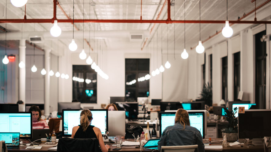 Une scène de bureau animée avec des professionnels qui travaillent assidûment sur des ordinateurs, favorisant la productivité et la collaboration.