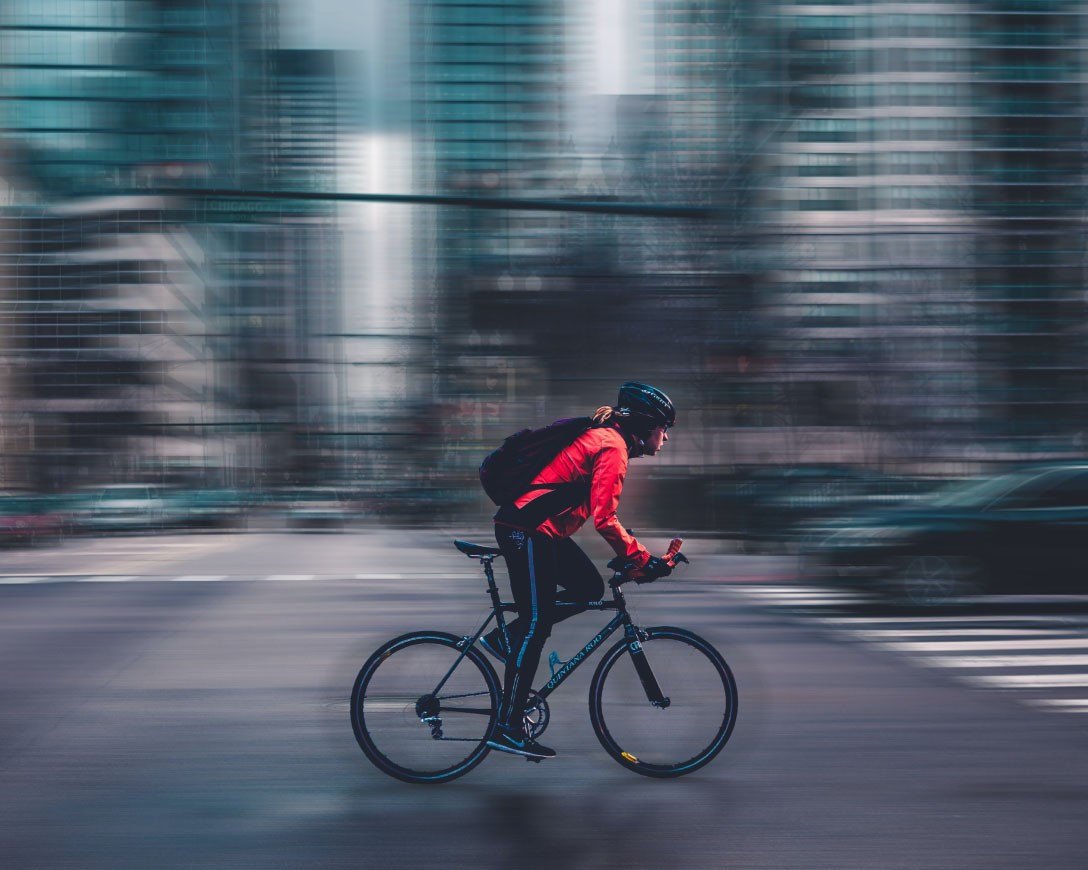 Un cycliste se déplaçant à vélo dans une rue animée de la ville.